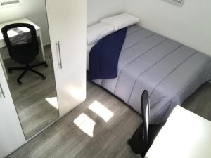 a bedroom with a bed and a chair and a mirror at MODERNO NUEVO Luminoso WI-FI PLAZA DEL PILAR 2 in Zaragoza