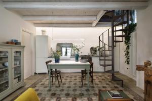 a dining room with a table and a spiral staircase at Nicotera Apartment in Noto