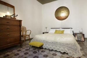 a bedroom with a bed and a dresser and a chair at Nicotera Apartment in Noto