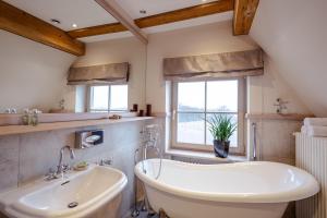 a bathroom with a white tub and a sink at Zamek Topacz in Wrocław