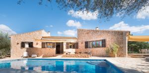 a villa with a swimming pool in front of a house at Mallorca Dream in Ses Salines