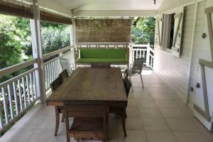 a wooden table on the porch of a house at Villa Le Capitaine à 30 mètres du lagon in La Saline les Bains