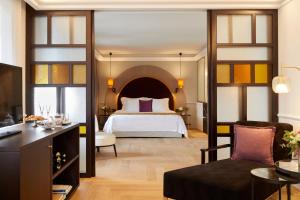 a hotel room with a bed and a couch at The Excelsior - Small Luxury Hotels of the World in Thessaloniki