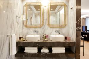 a bathroom with two sinks and a mirror and towels at The Excelsior - Small Luxury Hotels of the World in Thessaloniki