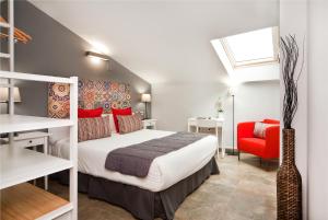 1 dormitorio con 1 cama y 1 silla roja en HOTEL SANT PERE ll HSPII, en Rubí