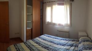 1 dormitorio con cama y ventana en Departamento Victoria Bariloche en San Carlos de Bariloche