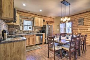 a kitchen with a table and chairs and a refrigerator at Stylish Creekside Cabin with Fire Pit Near Wineries! in Pittsville