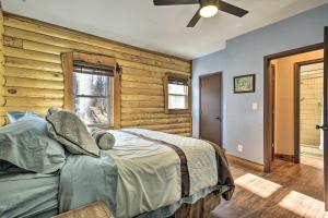 a bedroom with a bed and a wooden wall at Stylish Creekside Cabin with Fire Pit Near Wineries! in Pittsville