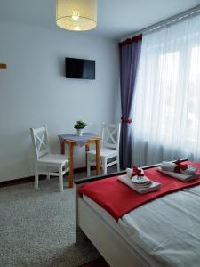 1 dormitorio con 1 cama, mesa y sillas en Pokoje u Agi, en Zakopane