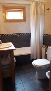 ein Badezimmer mit einer Badewanne, einem WC und einem Waschbecken in der Unterkunft Departamento Victoria Bariloche in San Carlos de Bariloche
