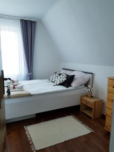a bedroom with a large white bed with a window at Pokoje u Agi in Zakopane