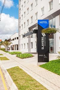 a sign for a hotel in front of a building at Slaviero Curitiba Aeroporto in São José dos Pinhais