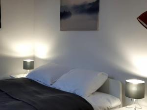 una camera da letto con un letto con lenzuola bianche e due lampade di PanCake Apartament Piotrkowska free parking a Łódź