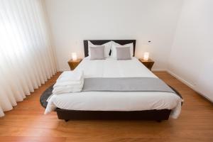 1 dormitorio con 1 cama blanca grande y 2 lámparas en Braga Luxury Residence 3854 en Braga