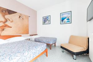 a bedroom with a bed and a chair and a painting at Lia Rooms 2 in La Spezia