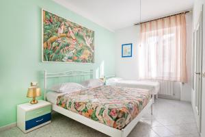 a bedroom with two beds and a painting on the wall at Lia Rooms 2 in La Spezia