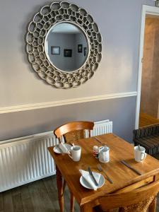 a dining room table with a mirror on the wall at The Fife Arms Hotel in Keith