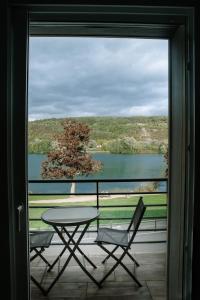 a patio with a table and chairs and a view of a lake at Balcons sur Seine - Vernon Giverny in Vernon