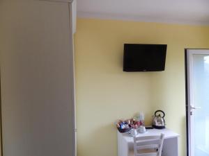 Pokój z telewizorem na ścianie i krzesłem w obiekcie Il Melograno w Albendze
