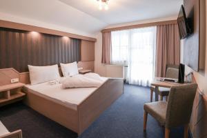 a hotel room with a bed and a desk and a computer at Golf & Skipension Krug in Haus im Ennstal