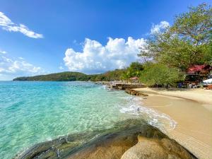 a beach with turquoise water and a sandy shore at Banthaisangthain Resort in Ko Samed