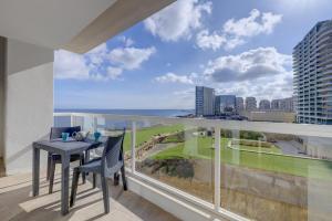 balcone con tavolo, sedie e vista sull'oceano di Apartment with Stunning Seaviews a Sliema