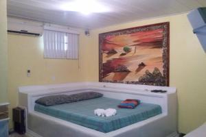 1 cama en una habitación con un cuadro en la pared en OYO TBS Hotel, en Manacapuru
