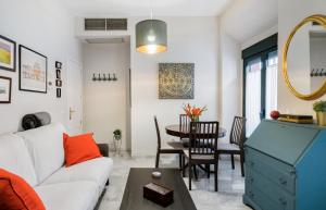 a living room with a white couch and a table at Casa San Martín Sevilla in Seville