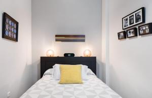 a bedroom with a bed with a yellow pillow on it at Casa San Martín Sevilla in Seville