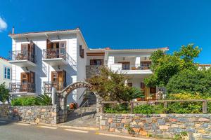 uma casa branca com uma parede de pedra em Hotel PARALIAKO Kyparissi em Kyparissia