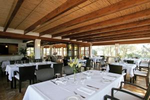 a dining room with white tables and chairs at Hotel Rural & Spa Can Curreu in Sant Carles de Peralta