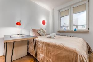 1 dormitorio con 1 cama, escritorio y ventana en Apartments City Center Warsaw by Renters en Varsovia