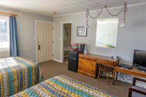 a bedroom with a bed and a desk with a computer at The Brookside Inn in Ludlow