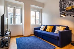 a living room with a blue couch and a tv at 3 bedroom apt near Av. Liberdade in Lisbon
