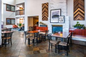 a restaurant with tables and chairs and a fireplace at Best Western Vista Inn at the Airport in Boise