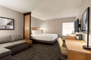 um quarto de hotel com uma cama e um sofá em Hyatt Place Tucson Central em Tucson