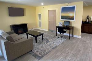 sala de estar con sofá, escritorio y TV en Days Inn by Wyndham Atlanta/Southlake/Morrow en Morrow