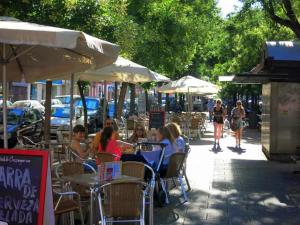 a group of people sitting at tables in an outdoor cafe at Apartamento en Retiro in Madrid