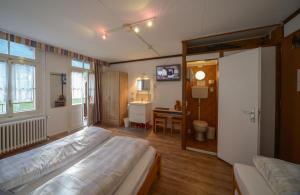 um quarto com uma cama, uma secretária e um espelho em Swiss Lodge Hotel Bernerhof em Wengen