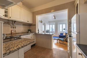 a kitchen with white cabinets and a counter top at 3 bedroom apt near Av. Liberdade in Lisbon
