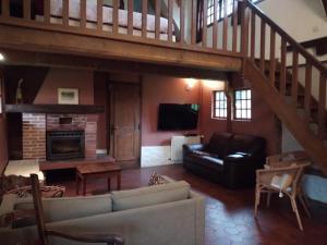 a living room with a couch and a staircase at La Chaumière aux Faisans in Ablon