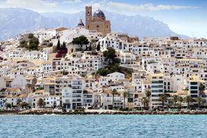 a group of white buildings on a hill next to the water at Sabater in Altea