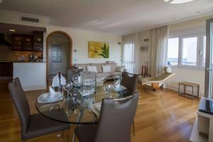 a dining room and living room with a glass table and chairs at Sabater in Altea