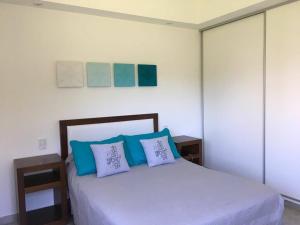 1 dormitorio con 1 cama con almohadas azules y blancas en Septiembre en Colón