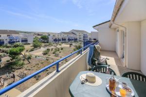 a table on a balcony with a view of the city at Résidence Pierre & Vacances Bleu Marine in Lacanau-Océan