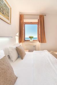 a bedroom with two beds and a window with the ocean at R club Apartments Old Town Budva in Budva