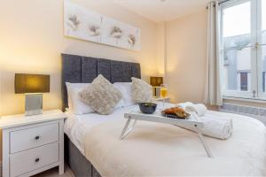a bedroom with a bed with a tray of food on it at Guest Homes - Trinity Flat in Worcester