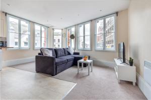 a living room with a couch and a tv at Guest Homes - Trinity Flat in Worcester