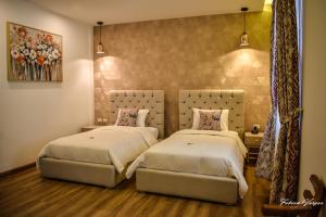 two beds in a room with two bedsitures at Adamas House Hotel Boutique in Quito