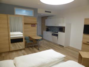 ein Wohnzimmer mit einer Küche und einem Tisch in der Unterkunft Leister Apparthotel in Weyhe